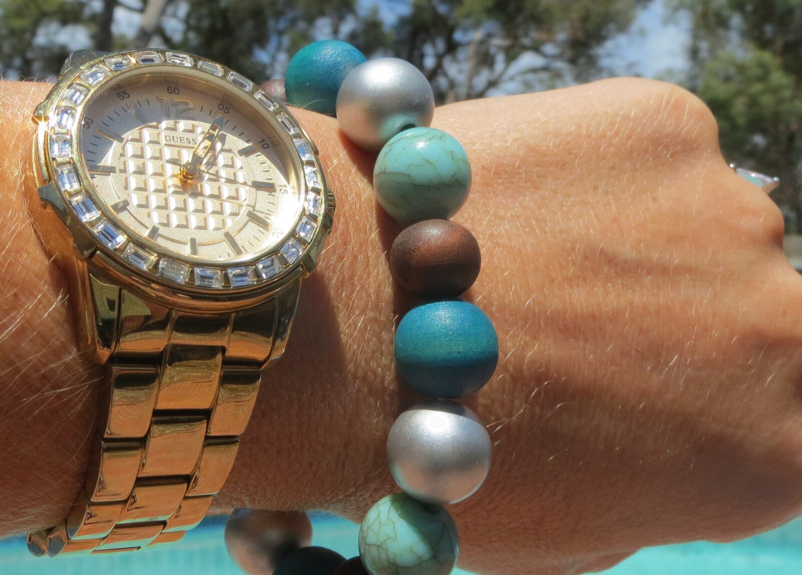 Green beaded bracelet, gold watch