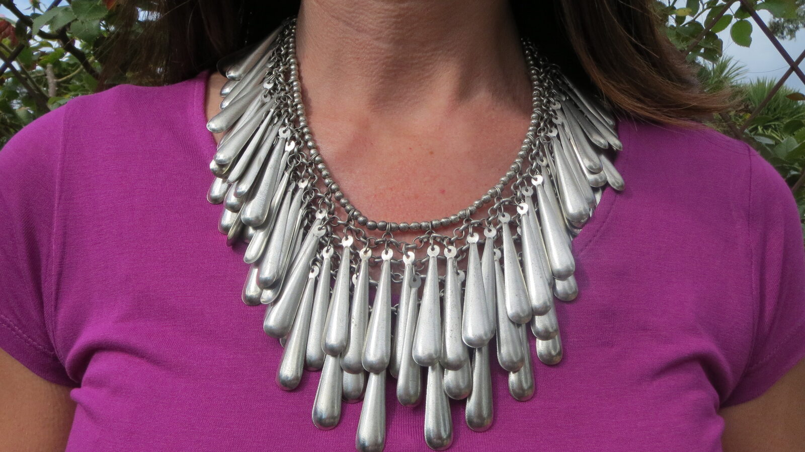 Silver neckpiece on purple top