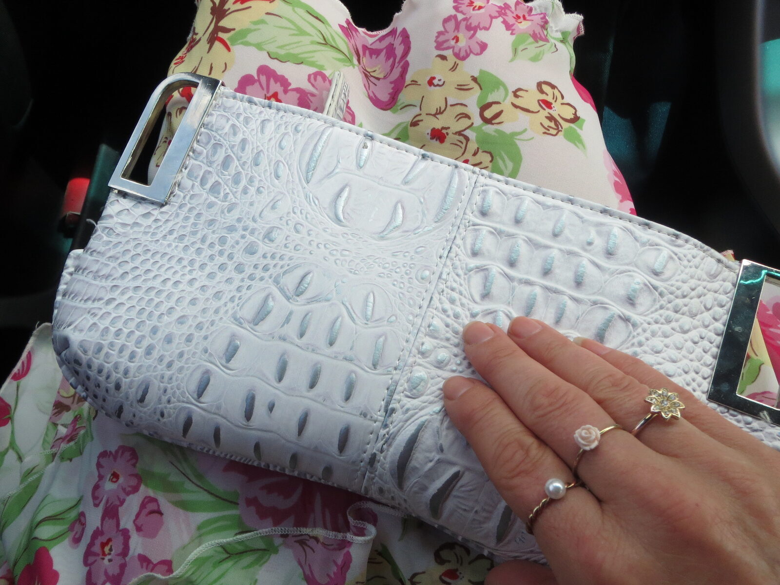 White clutch, floral skirt, rings
