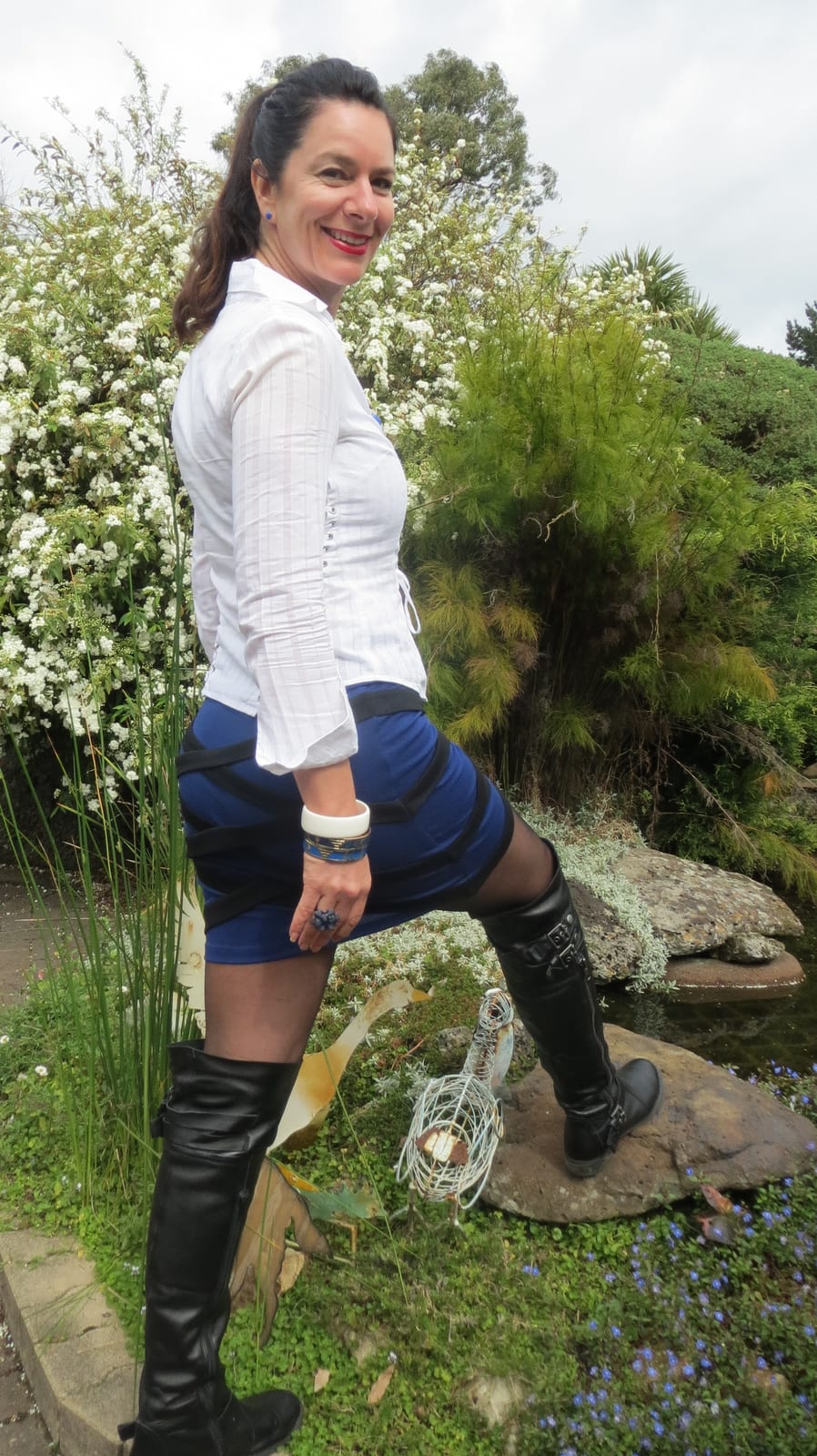 Fitted white lace-up shirt with three-quarter sleeves, worn with a blue bandage mini skirt and black knee-high boots